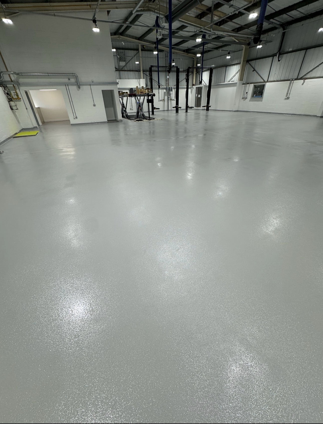 Automotive workshop London 300m² anti-slip epoxy resin floor with coving and line marking